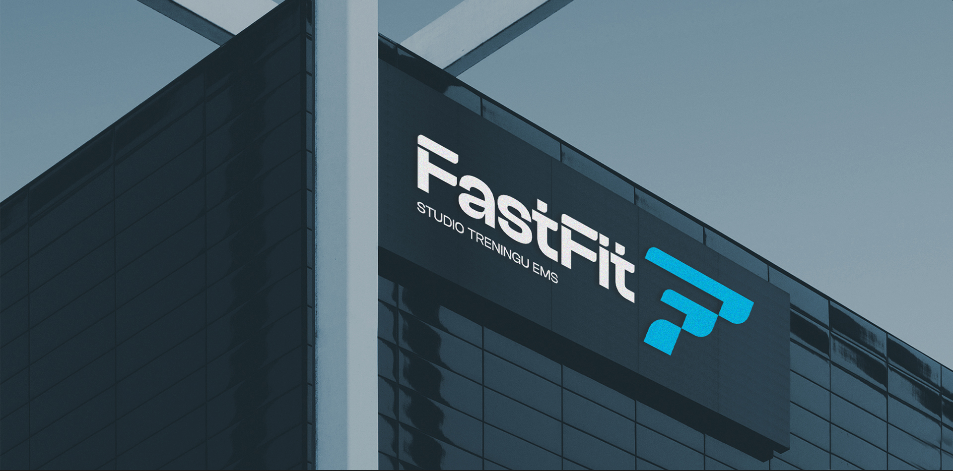 Zdjęcie przedstawiające logo Fast Fit Studio umieszczone na elewacji czarnego nowoczesnego budynku